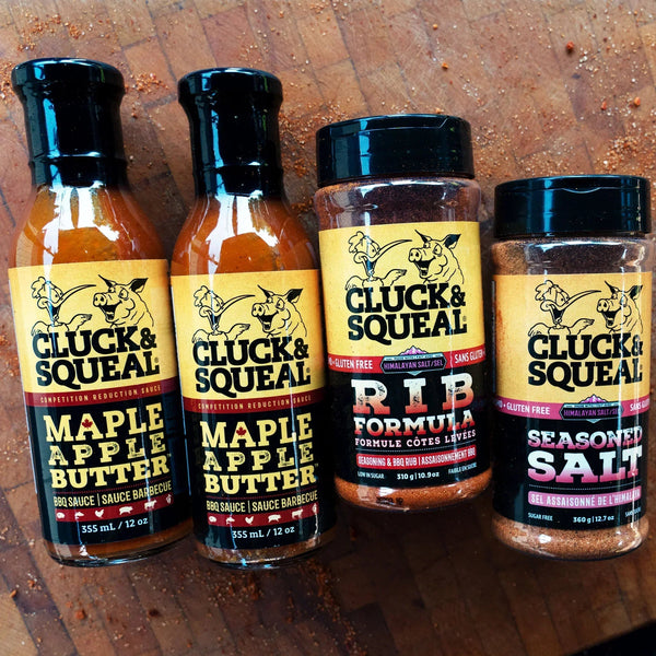 Cluck & Squeal Maple Apple Butter BBQ sauce and Rib Formula seasoning on wooden surface